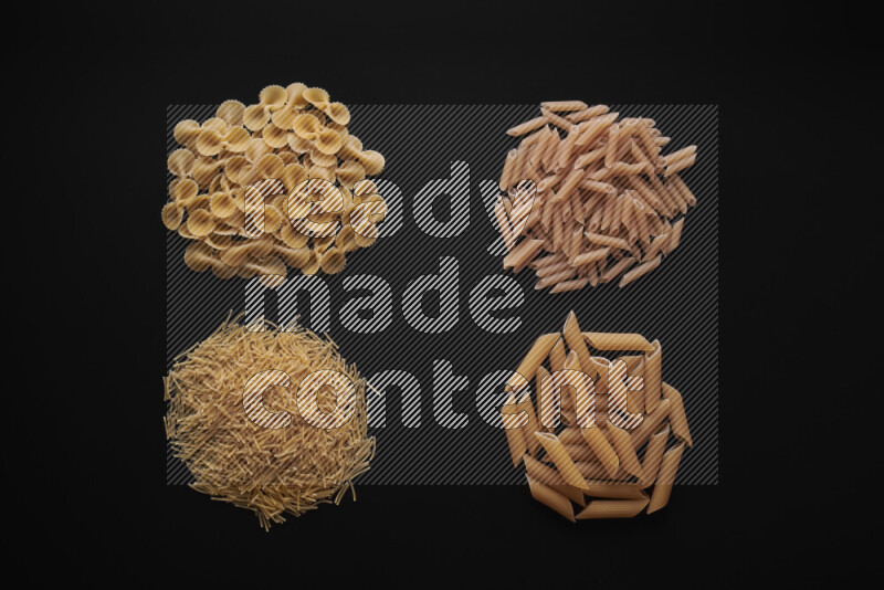 Different pasta types in bunches on black background
