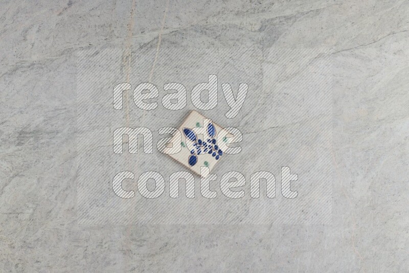 A decorative pottery coaster on grey marble background