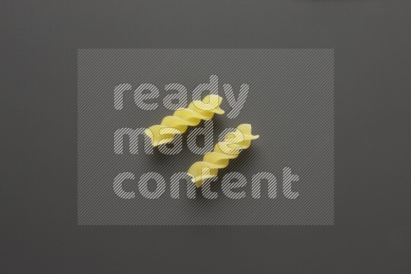 Fusilli pasta on grey background