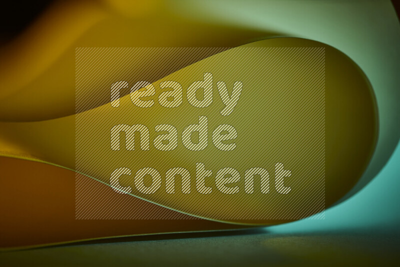 An abstract art piece displaying smooth curves in yellow and green gradients created by colored light