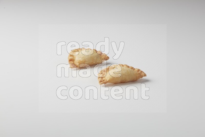 Two fried sambosas on a white background
