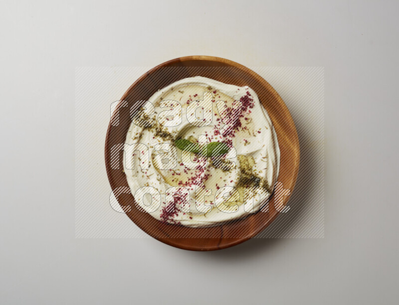Lebnah garnished with  zattar , sumak & mint in a wooden plate on a white background