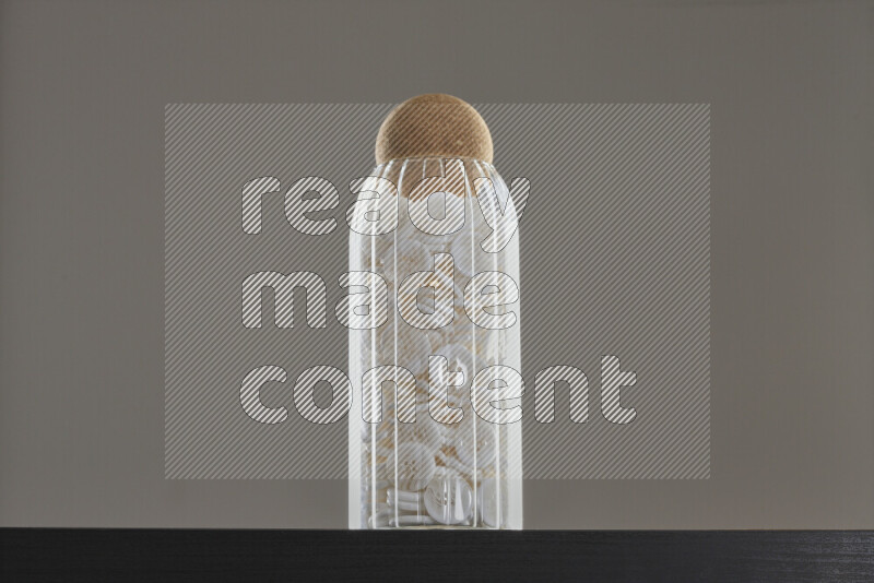 أزرار متنوعة في وعاء زجاجي علي خلفية سوداء