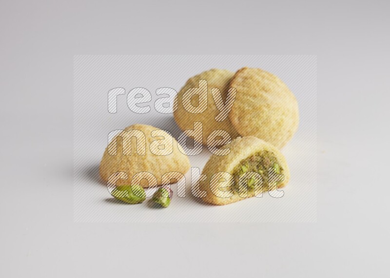 Four Pieces of Maamoul filled with pistachio  paste one of them is cut direct on white background