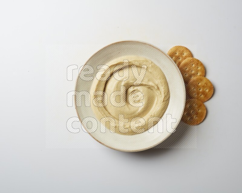 plain Hummus in a pottry plate  on a white background