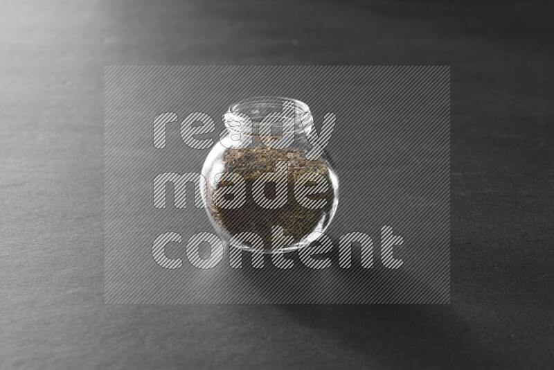 كمون في وعاء زجاجي علي خلفية سوداء