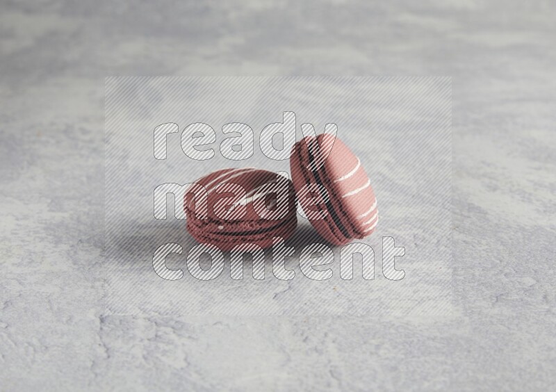45º Shot of two Red Poppy Flower macarons on white  marble background