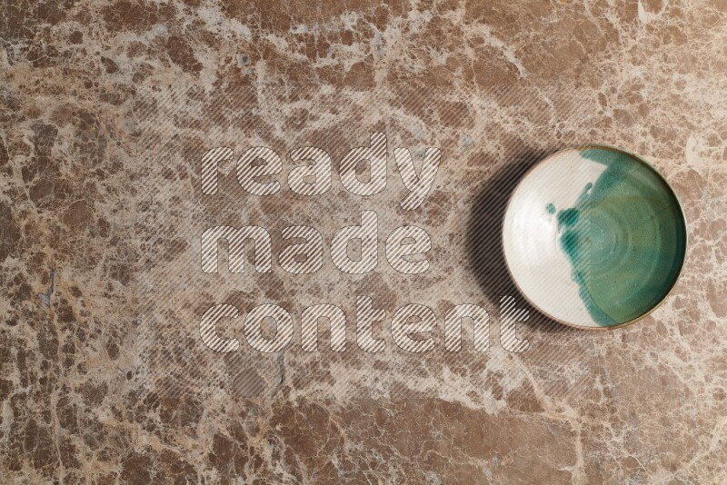 A decorative pottery plate on beige marble background