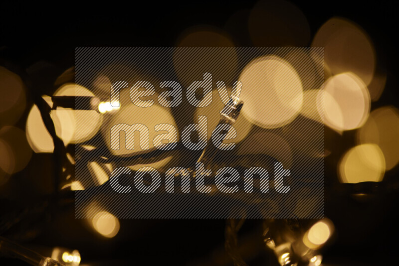 Light bulbs glowing against backdrop of golden bokeh