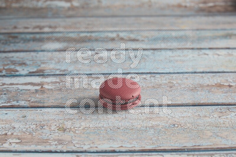 45º Shot of Red Cherry macaron on light blue wooden background