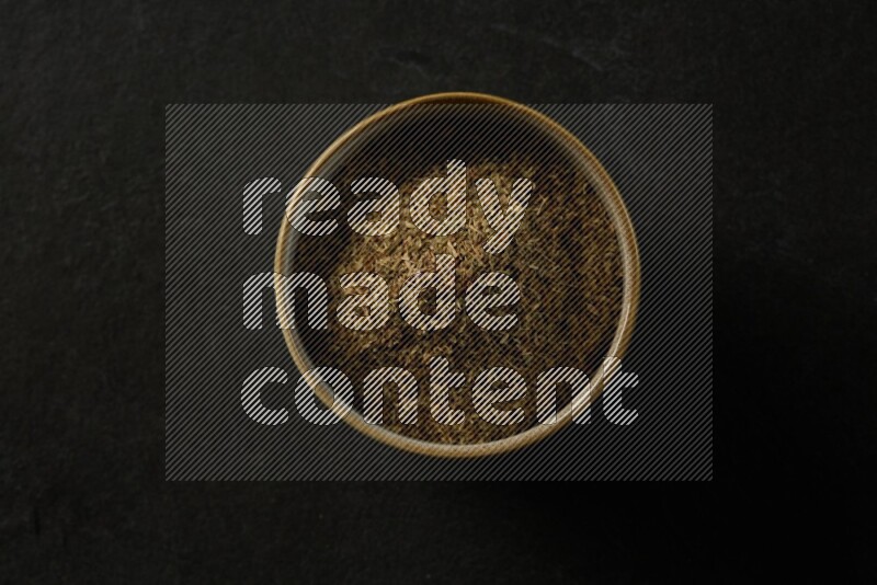 multi color round sauce bowl filled with herbs on grey textured countertop