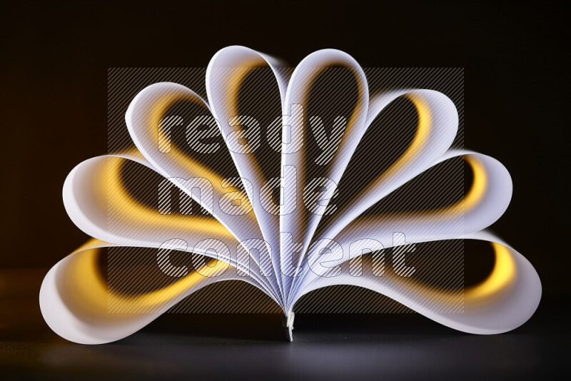 An abstract art piece displaying smooth curves in yellow and white gradients created by colored light