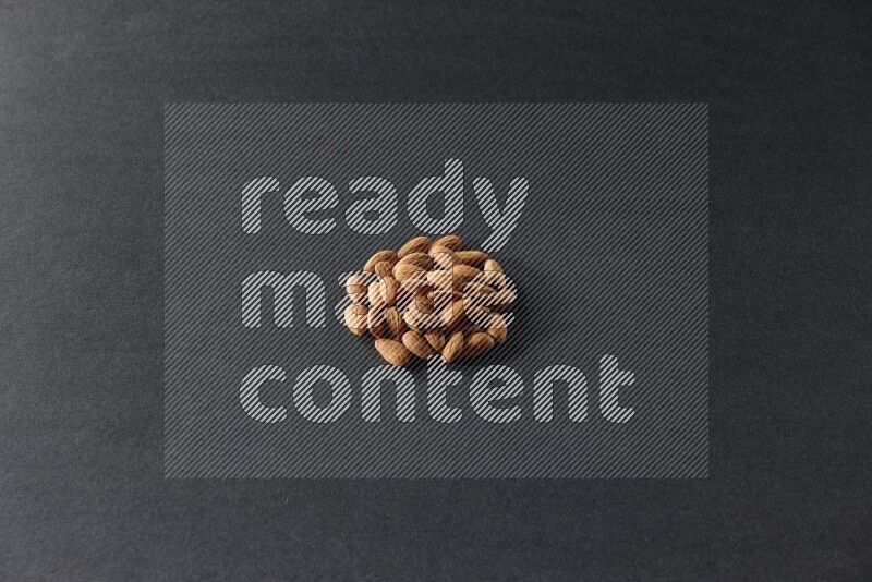 A bunch of peeled almonds on a black background in different angles