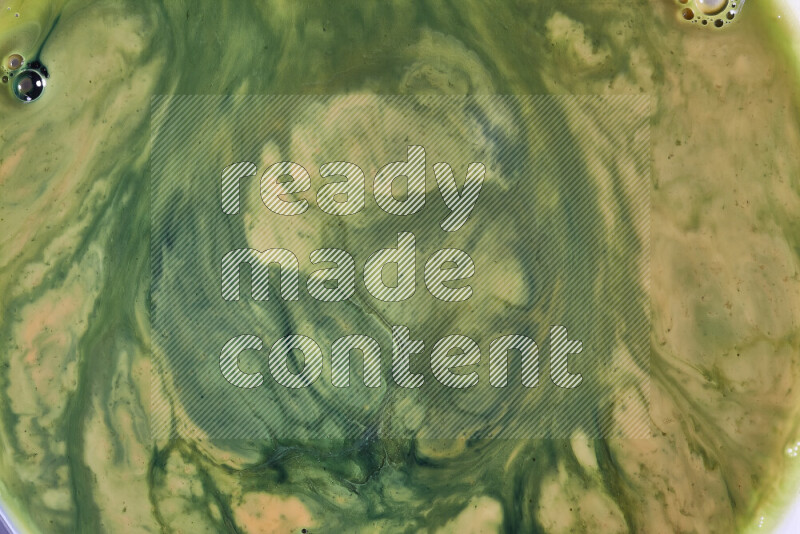 A close-up of abstract swirling patterns in orange and green