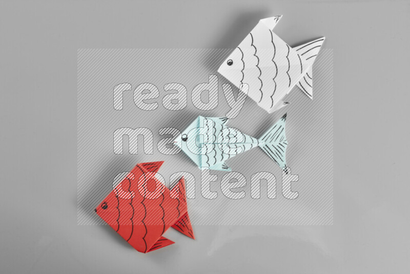 Origami fish on grey background
