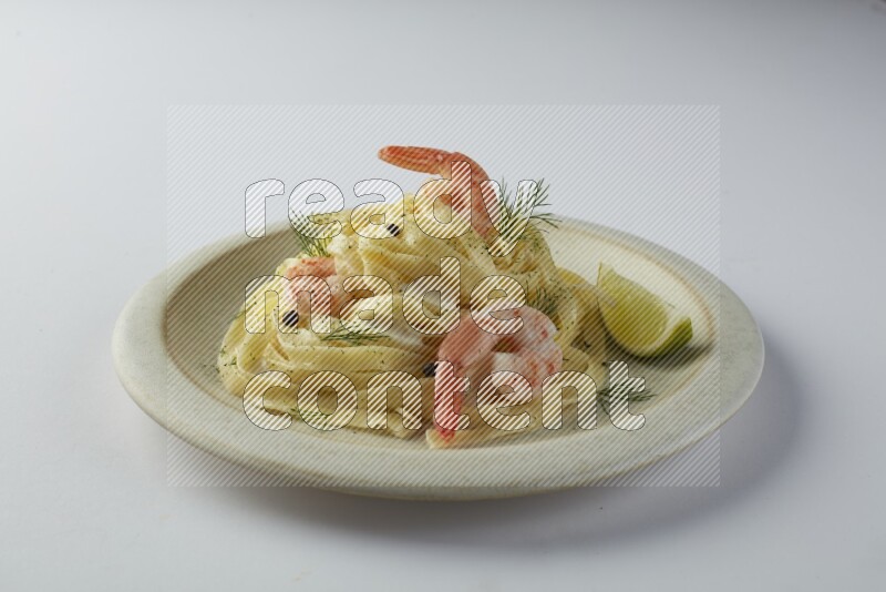 Fettuccini white sauce pasta with shrimp in a white plate on a white background