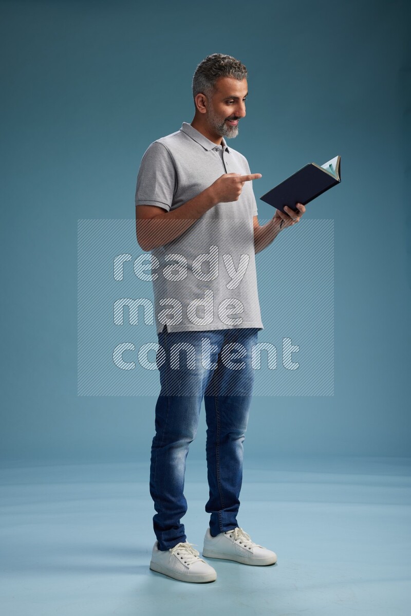Man Standing reading book on blue background