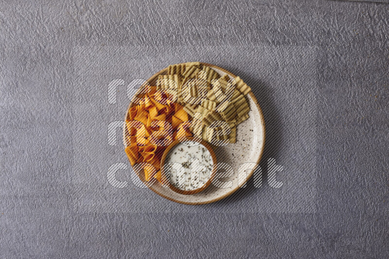 Assorted snacks in pottery bowls on grey background