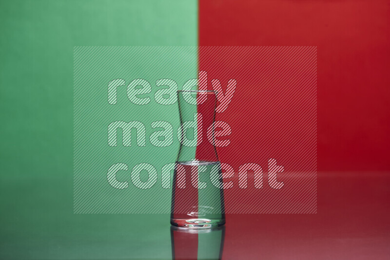 The image features a clear glassware filled with water, set against green and red background