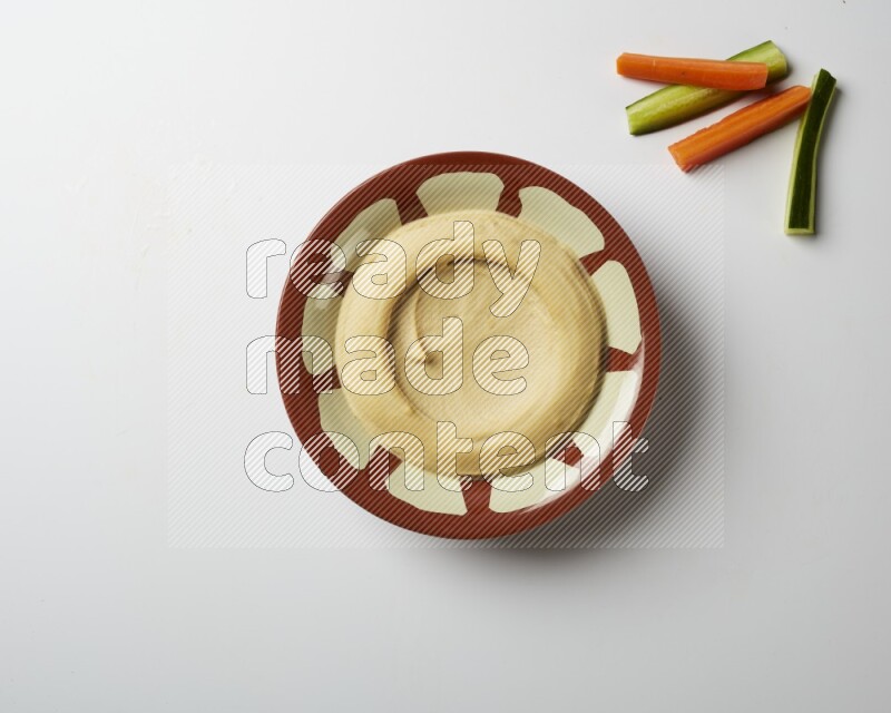 Plain hummus in a traditional plate on a white background