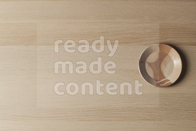 A multicolored pottery plate on light wooden background