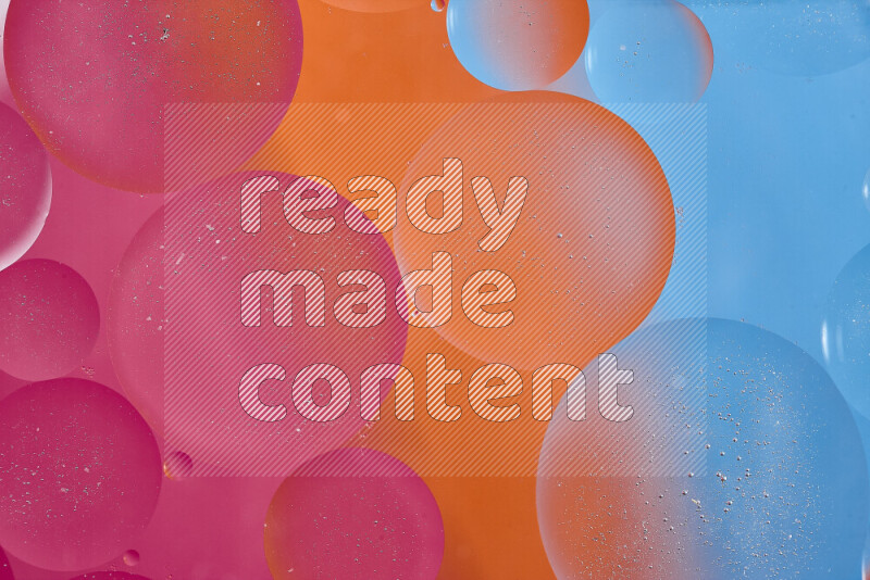 Close-ups of abstract oil bubbles on water surface in shades of blue, orange and pink