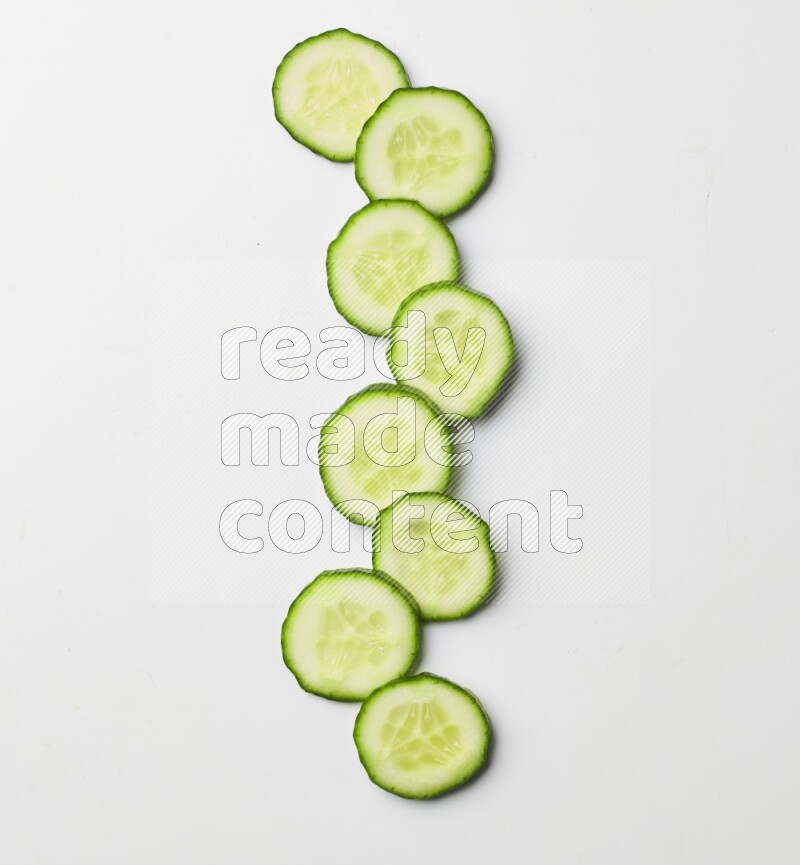 Multiple cucumber slices on white background