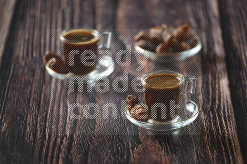 A coffee glass cup with dates and tea on wooden background