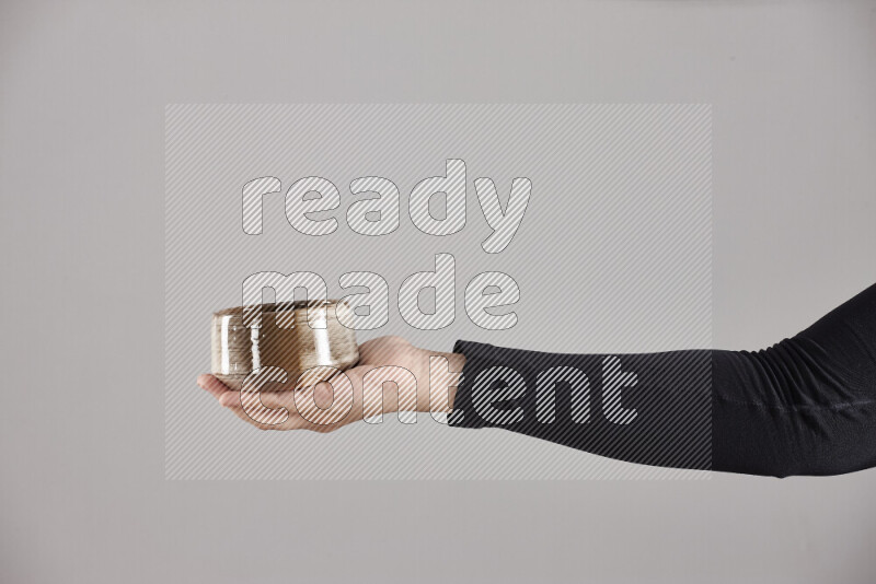 A woman in black abaya holding different pottery essentials in different positions