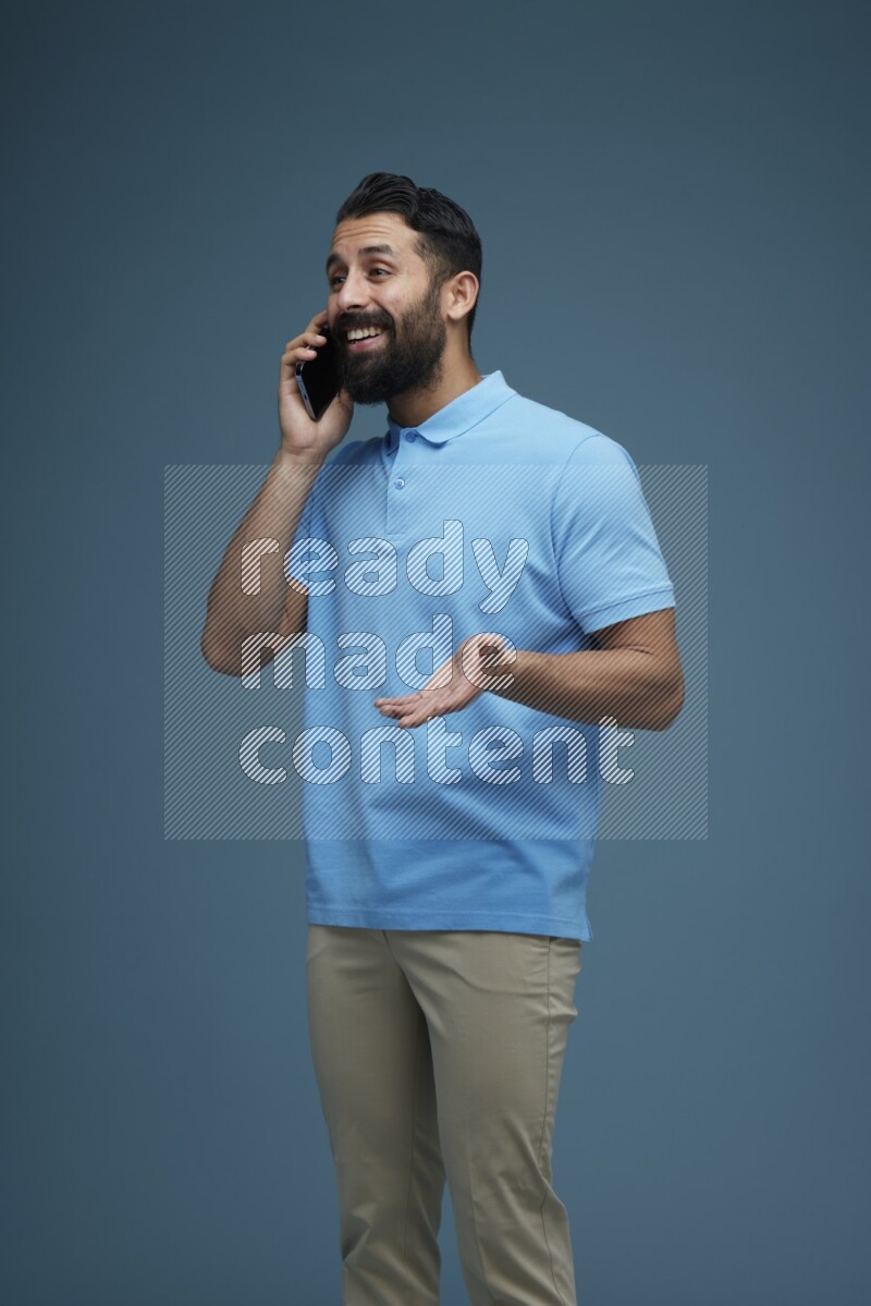 A man having a Call in a blue background wearing a Blue shirt