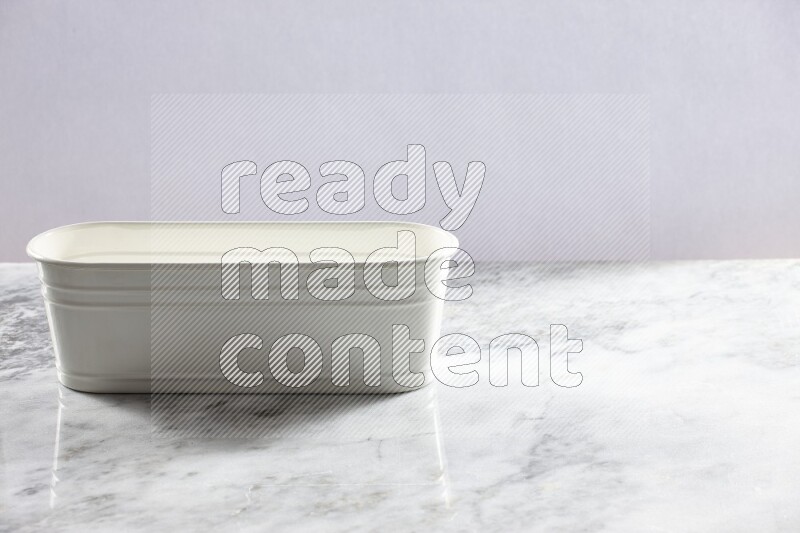 An empty white plant pot on grey marble background