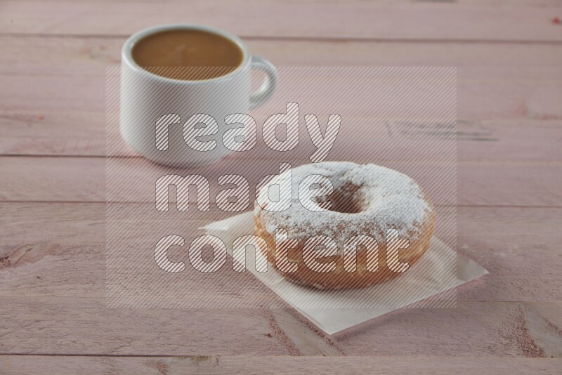 Sugar dusted doughnut on pink wooden background
