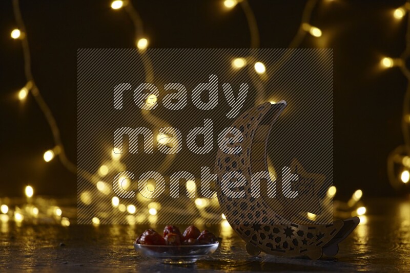 A traditional ramadan lantern surrounded by glowing fairy lights in a dark setup