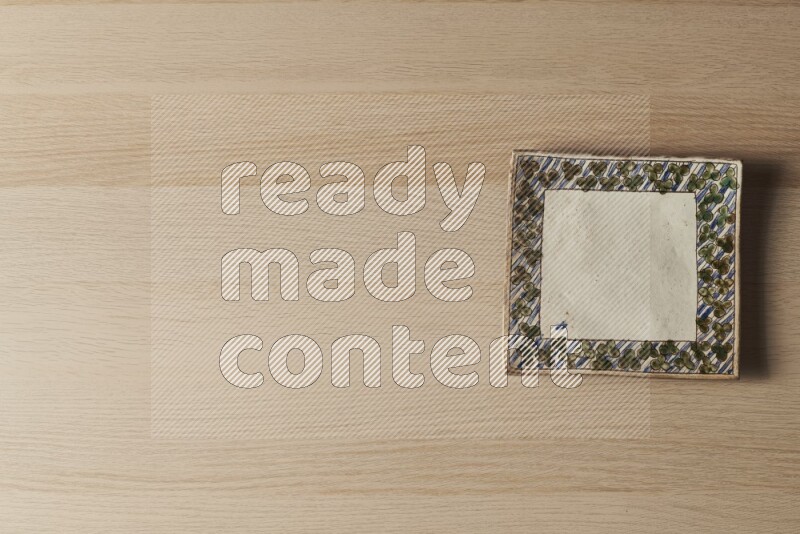 صحن فخاري مزخرف على خلفية خشبية فاتحة