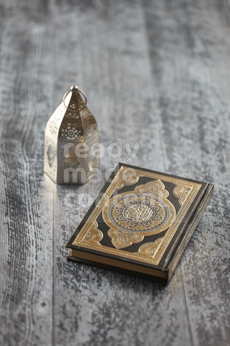 A silver lantern with different drinks, dates, nuts, prayer beads and quran on grey wooden background