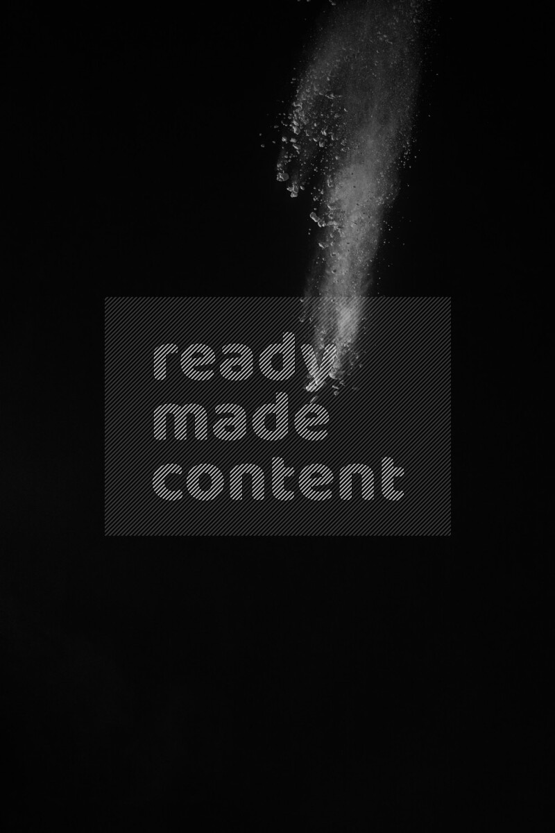 A side view of white powder explosion on black background