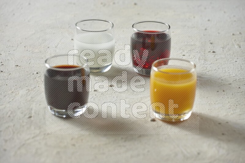 Cold drinks in a glass cup such as water, tamarind, qamar eldin, sobia, milk and hibiscus on textured white background
