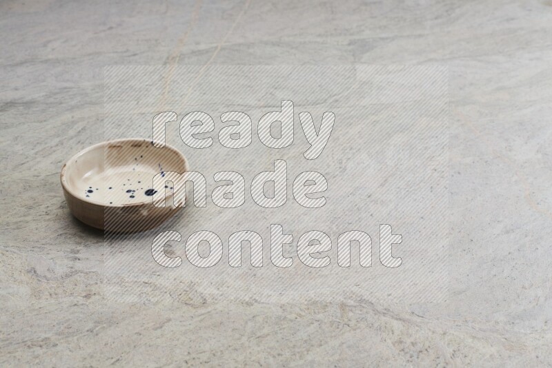 A multicolored pottery bowl on grey marble background