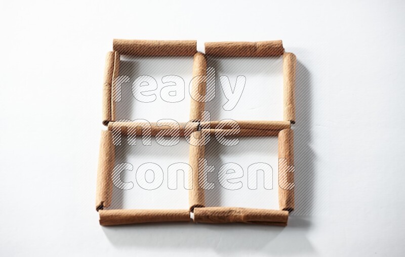 4 empty squares of cinnamon sticks on white flooring