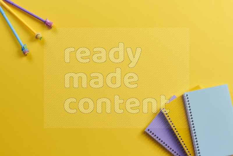 دفاتر ملاحظات متعددة الألوان مع مستلزمات مدرسية على خلفية صفراء