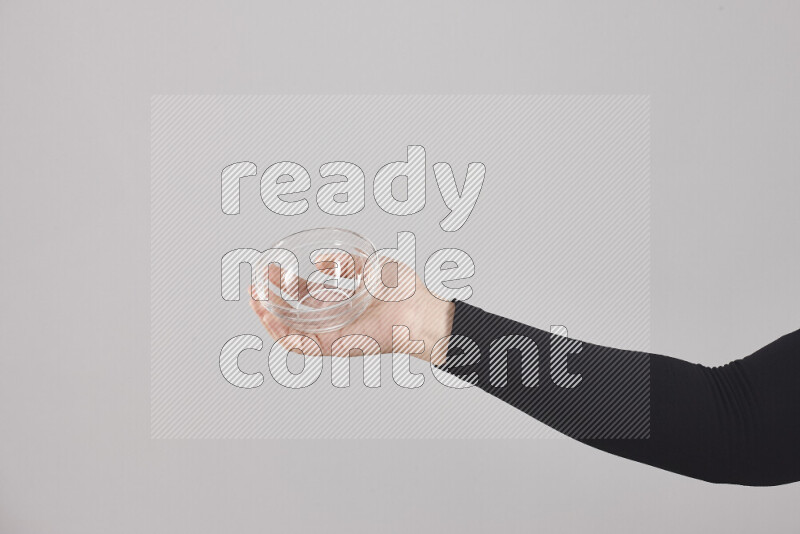 A woman in black abaya holding different glassware in different positions