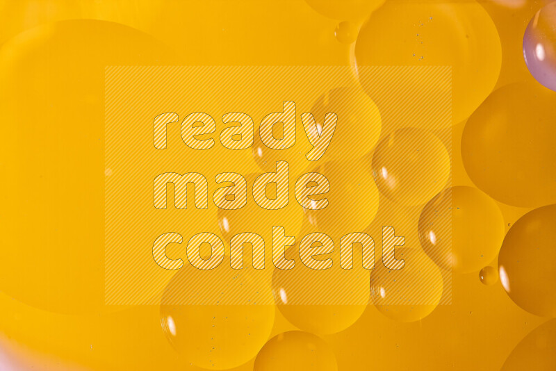 لقطات مقربة لفقاعات من الزيت على سطح الماء باللون البرتقالي