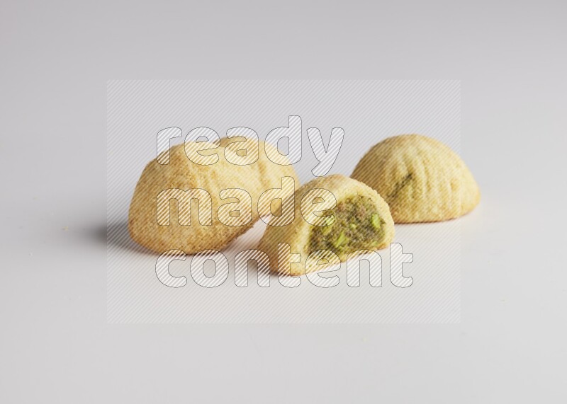 Four Pieces of Maamoul filled with pistachio  paste one of them is cut direct on white background