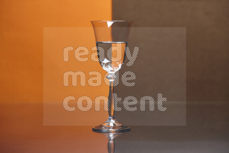 The image features a clear glassware filled with water, set against orange and brown background