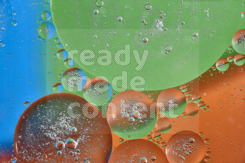 Close-ups of abstract oil bubbles on water surface in shades of orange, green and blue