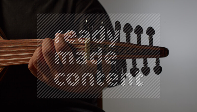 يد رجل تعزف على عود خشبي بني