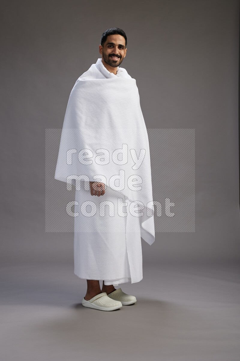 A man wearing Ehram Standing Interacting with the camera on gray background
