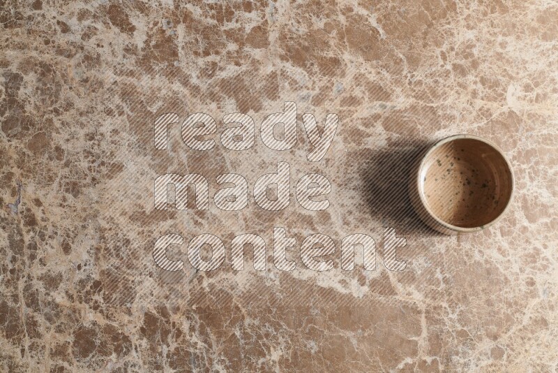 وعاء فخاري متعدد الألوان على خلفية من الرخام البيج