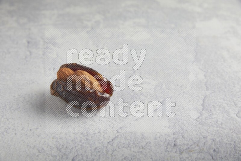 almond stuffed madjoul date on a light grey background