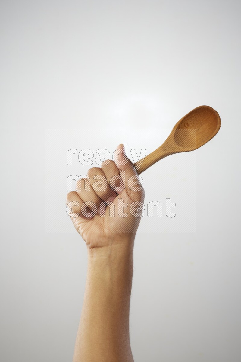 Male Hand Holding Wooden spoon on white background